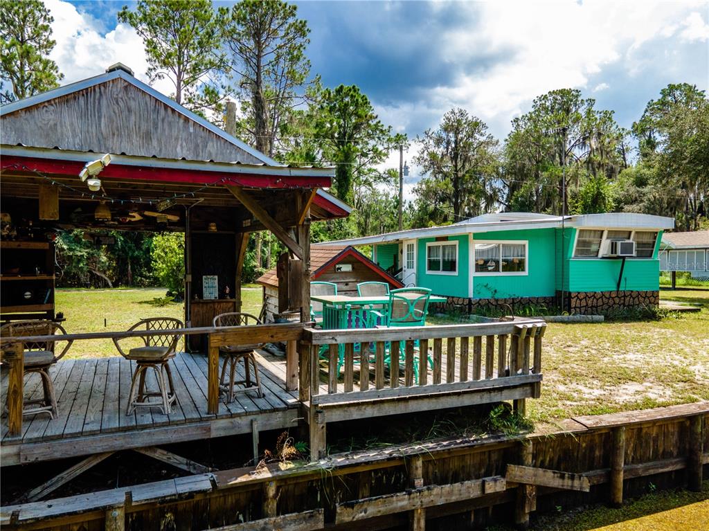 23673 Northeast 134th Lane Road Fort McCoy, FL 32134 - Photo 30 of 34 a view of a house with wooden deck and sitting area