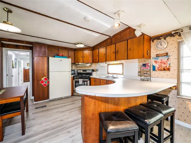 a kitchen with stainless steel appliances granite countertop a sink dishwasher cabinets and couches with a fireplace