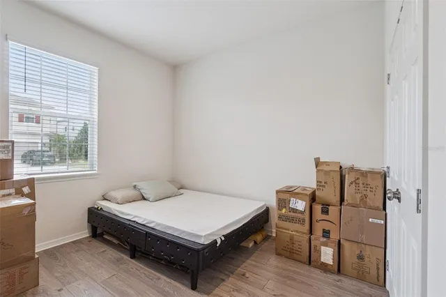 a bedroom with a bed and wooden floor