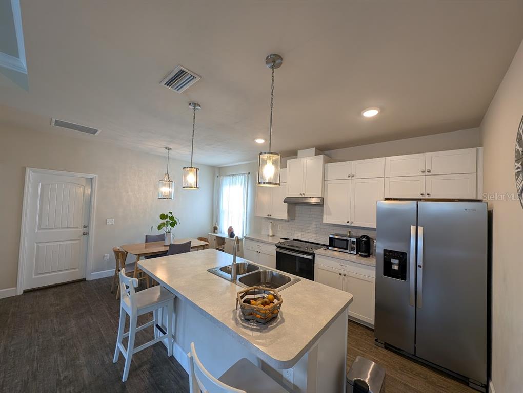 1750 Southwest 246th Drive Newberry, FL 32669 - Photo 7 of 18 a kitchen with refrigerator cabinets dining table and chairs