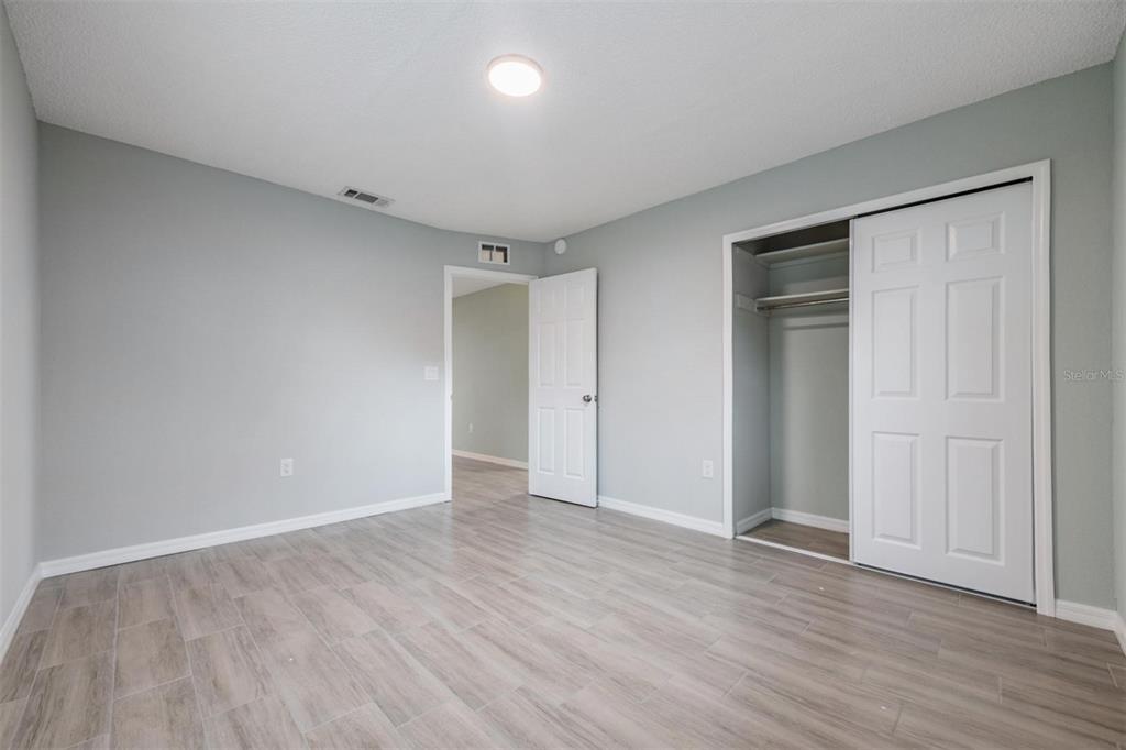 7802 Butler Avenue Hudson, FL 34667 - Photo 11 of 30 a view of an empty room with wooden floor and closet area