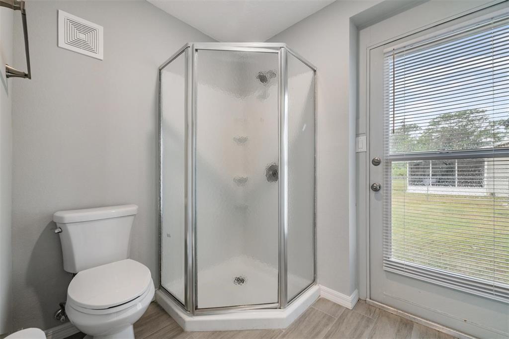 7802 Butler Avenue Hudson, FL 34667 - Photo 15 of 30 a bathroom with a toilet and a shower