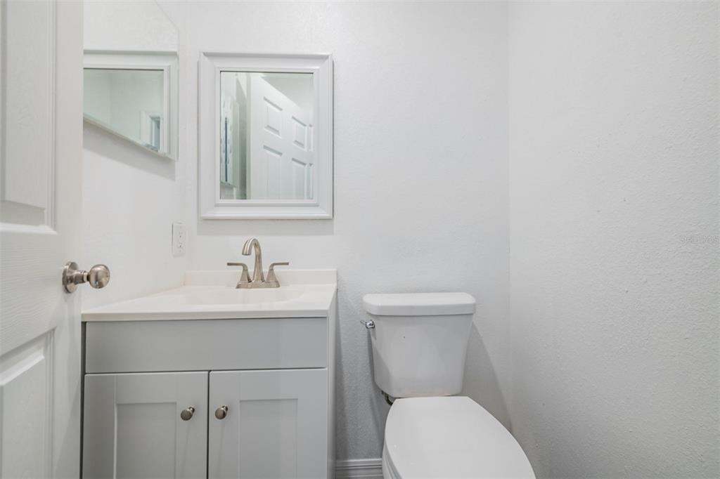 7802 Butler Avenue Hudson, FL 34667 - Photo 17 of 30 a bathroom with a toilet sink vanity and mirror