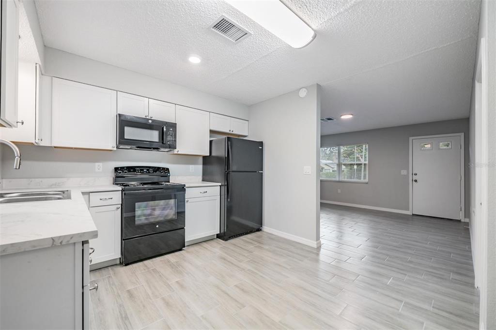 7802 Butler Avenue Hudson, FL 34667 - Photo 6 of 30 a kitchen with kitchen island a refrigerator stove and sink