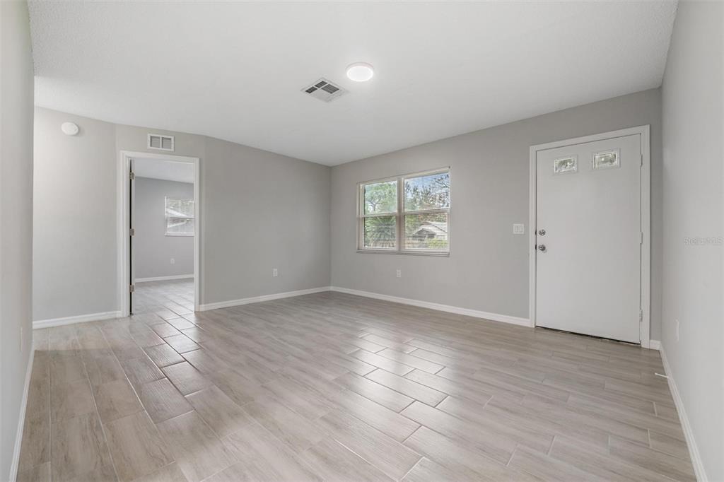7802 Butler Avenue Hudson, FL 34667 - Photo 9 of 30 an empty room with wooden floor and windows