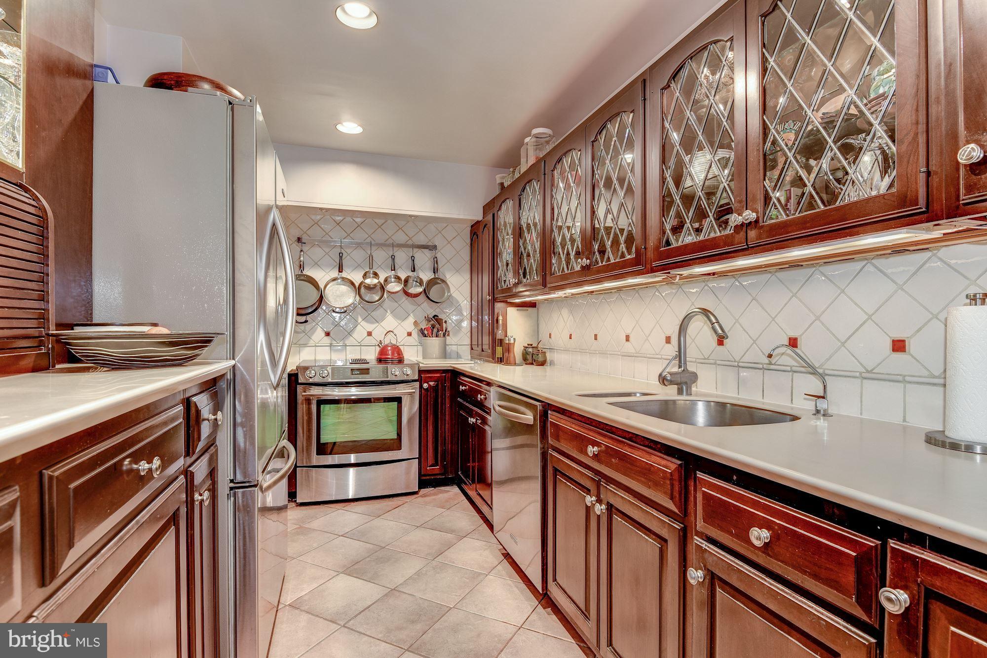 1610 32nd Street Northwest Washington, DC 20007 - Photo 21 of 27 a kitchen with stainless steel appliances granite countertop a sink stove and cabinets