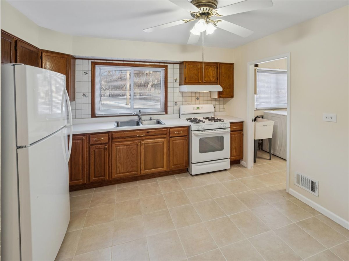 115 West Helen Road Palatine, IL 60067 - Photo 7 of 16 a kitchen with stainless steel appliances a sink a stove a refrigerator cabinets and a window