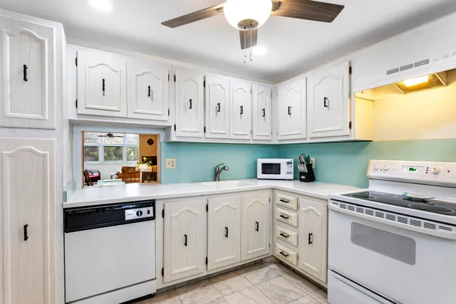 a kitchen with white cabinets and white appliances