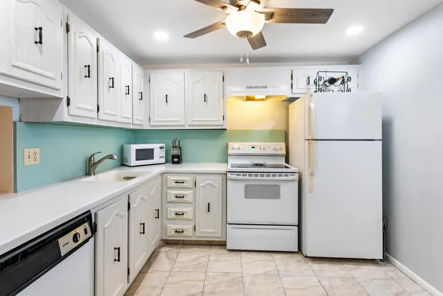 a kitchen with cabinets appliances a sink and a window