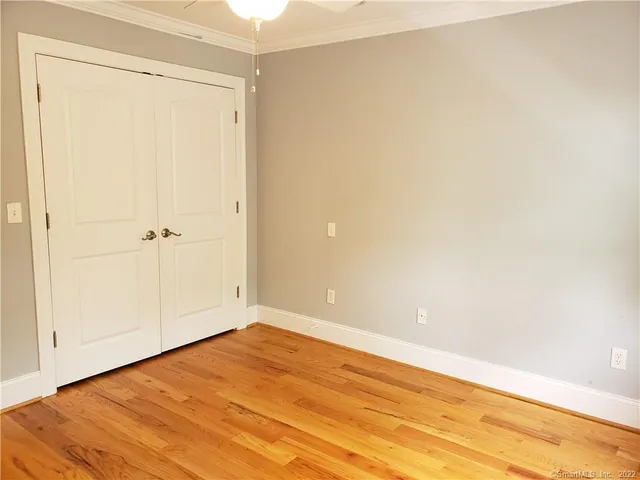 an empty room with wooden floor and closet