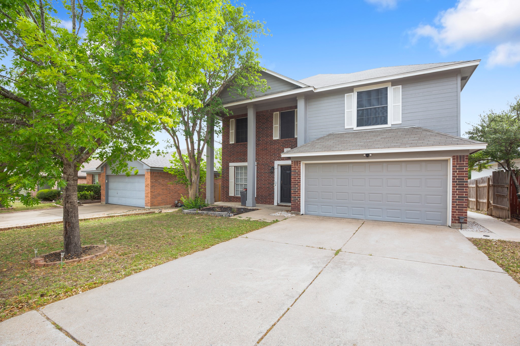 View of front of property with driveway, brick siding, and a garage