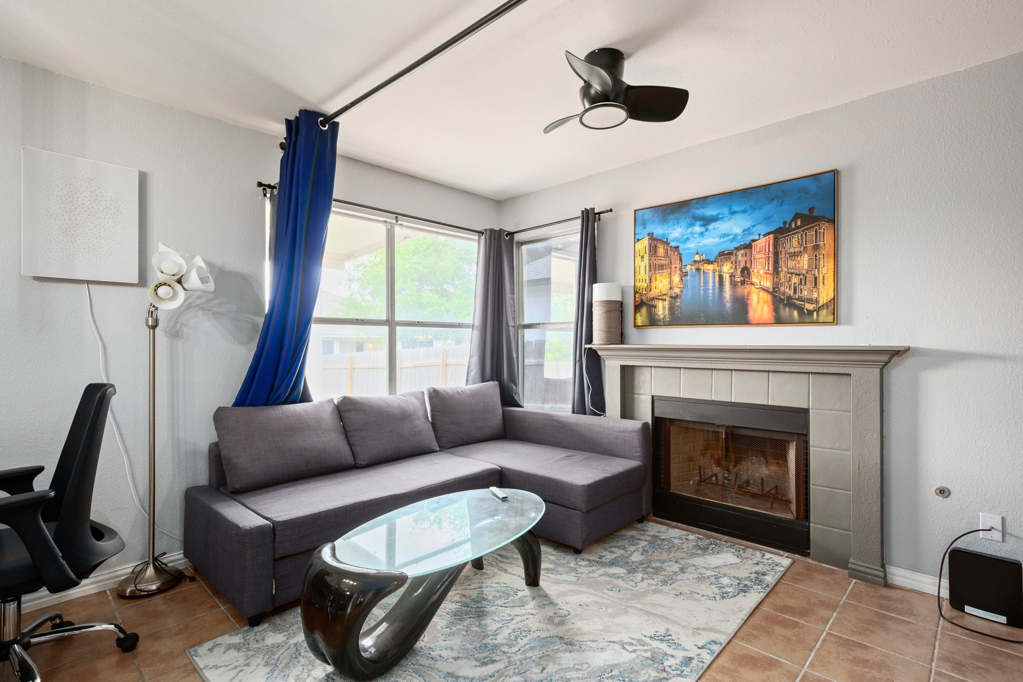 13803 Randalstone Drive Pflugerville, TX 78660 - Photo 16 of 27 Living area with a tiled fireplace, ceiling fan, and light tile patterned floors