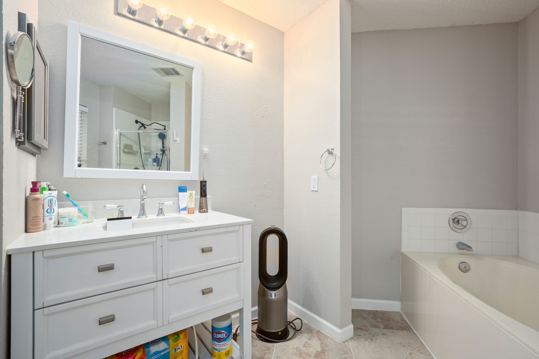 13803 Randalstone Drive Pflugerville, TX 78660 - Photo 25 of 27 Bathroom featuring vanity, a bath, a stall shower, and a textured ceiling