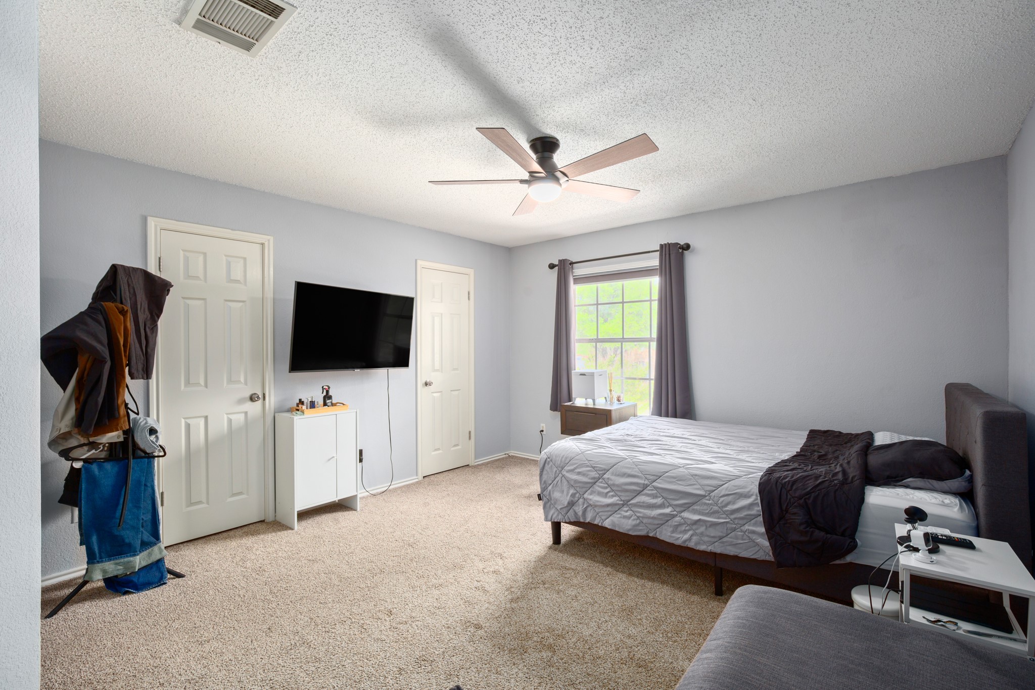13803 Randalstone Drive Pflugerville, TX 78660 - Photo 26 of 27 Bedroom featuring light colored carpet, a textured ceiling, and a ceiling fan