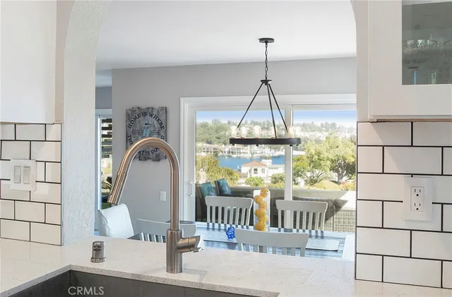 a kitchen with a sink dishwasher a stove and white cabinets with wooden floor
