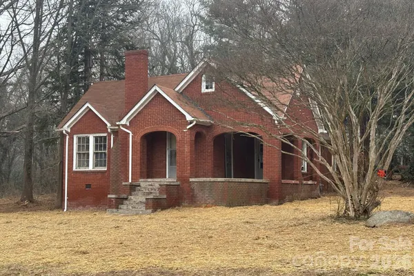 a front view of a house with a yard covered in snow