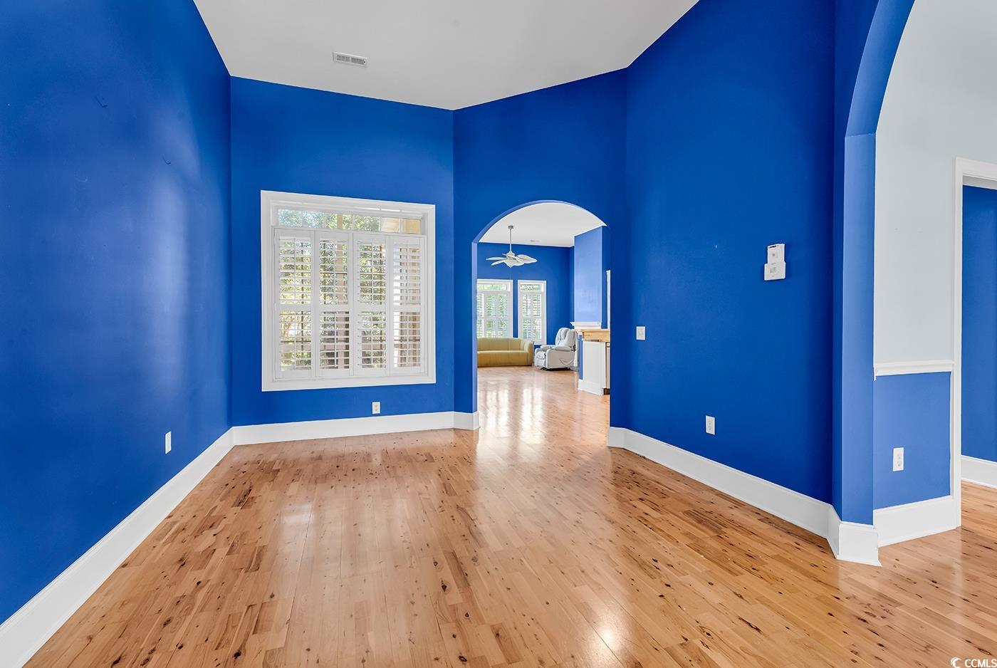 553 Linton Park Road Myrtle Beach, SC 29579 - Photo 3 of 40 Spare room with arched walkways, wood-type flooring, and a high ceiling