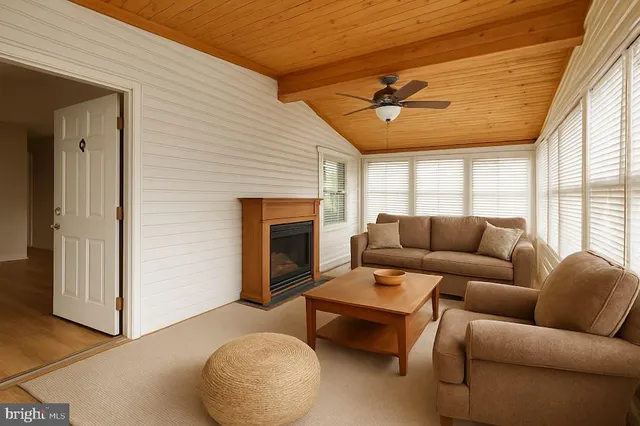 a living room with furniture a fireplace and a large window