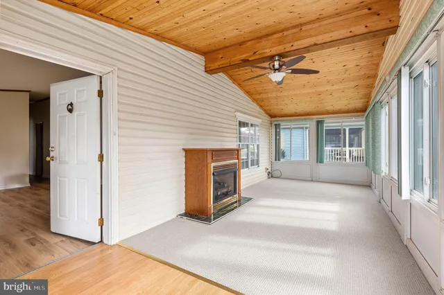a view of a porch with a floor to ceiling window and a kitchen