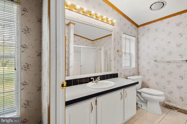 a bathroom with a granite countertop sink a toilet and a mirror
