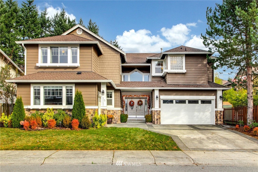 27752 Maple Ridge Way Southeast Maple Valley, WA 98038 - Photo 1 of 25 a front view of a house with a yard and garage