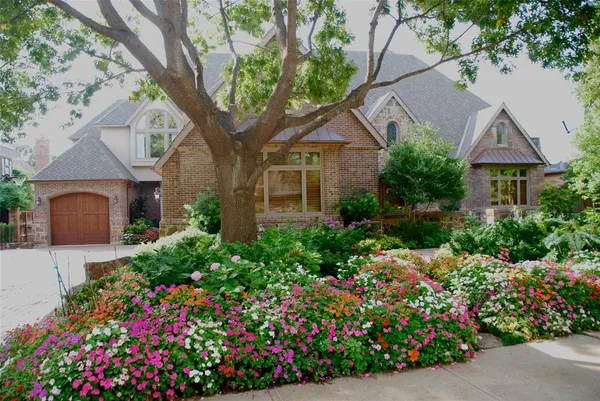 a front view of a house with a yard and fountain in middle of the house