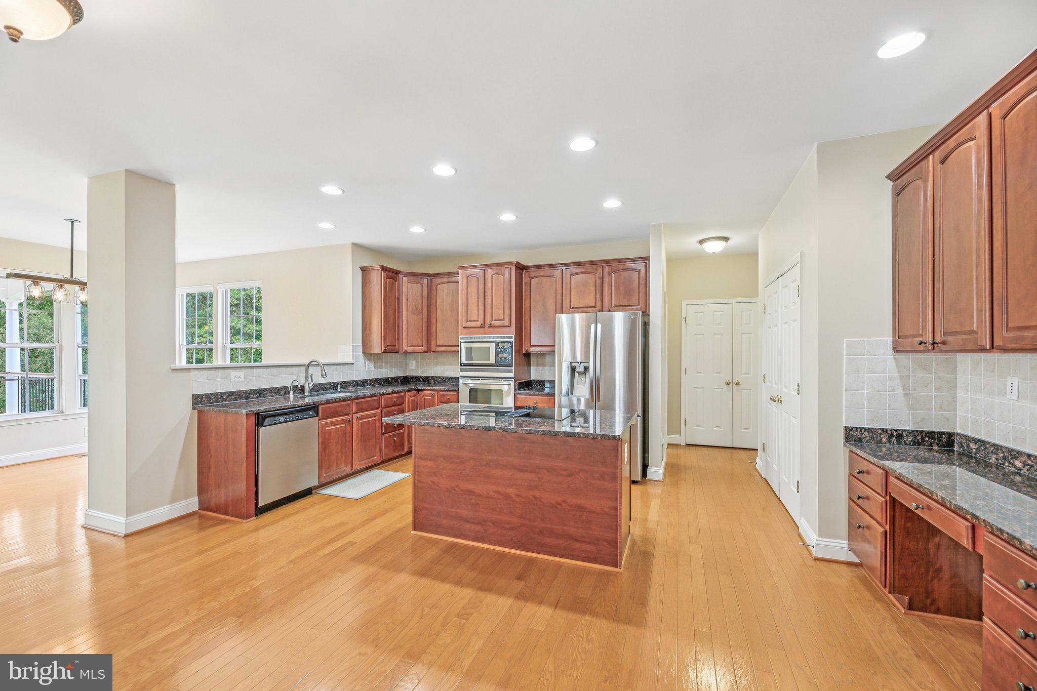 705 Jaclyn Circle Freeland, MD 21053 - Photo 11 of 45 a large kitchen with stainless steel appliances granite countertop a large counter top a stove a sink a refrigerator and white cabinets