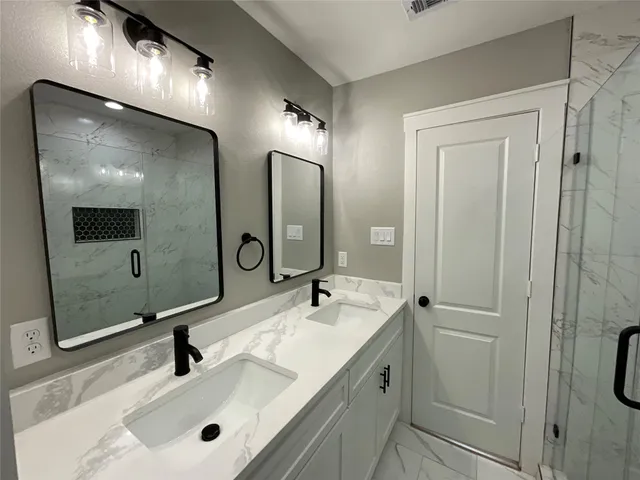 a bathroom with a double vanity sink and mirror