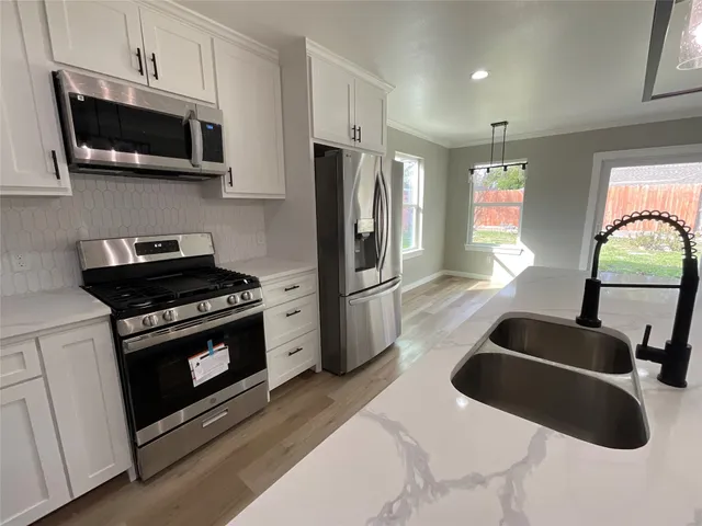 a kitchen with stainless steel appliances granite countertop a stove microwave and refrigerator