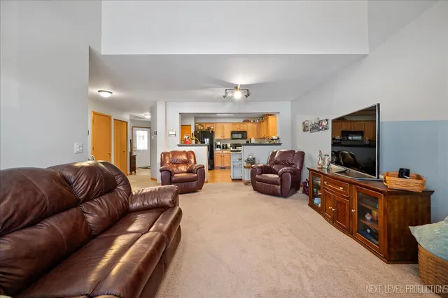 a living room with furniture a ceiling fan and a flat screen tv