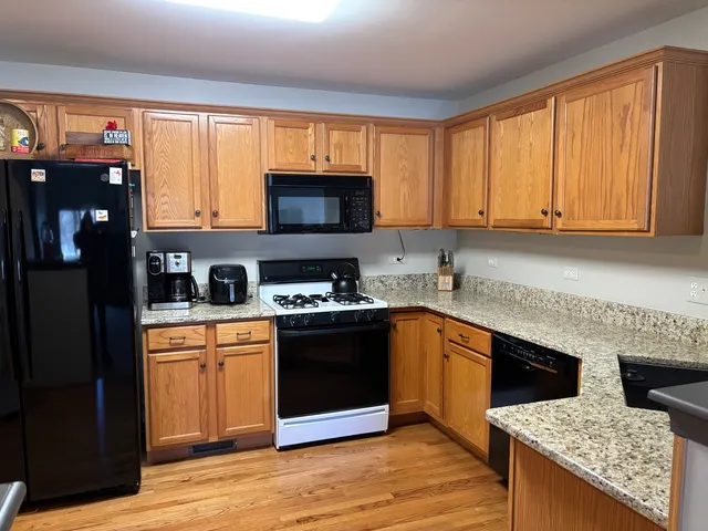 a kitchen with stainless steel appliances granite countertop a stove a sink and a microwave