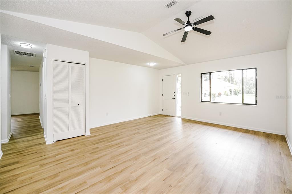 26 Seneca Path Palm Coast, FL 32164 - Photo 2 of 15 an empty room with wooden floor ceiling fan and windows