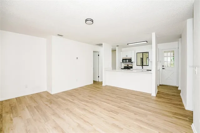 a view of a kitchen with wooden floor and a refrigerator