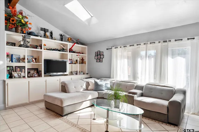 a living room with furniture a flat screen tv and a potted plant
