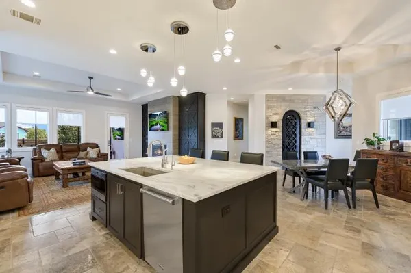 a large kitchen with kitchen island a sink a stove a dining table and chairs