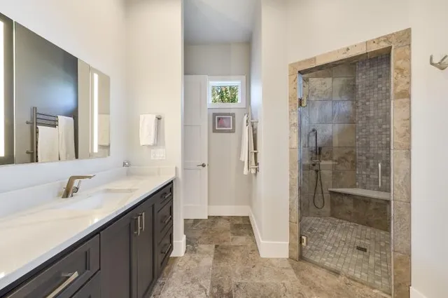 a bathroom with a shower sink and mirror