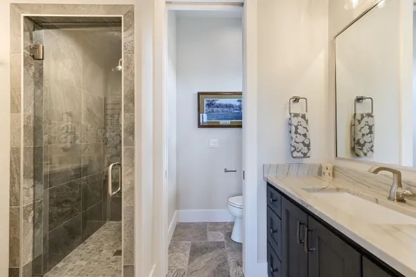 a bathroom with a granite countertop sink a mirror and a shower