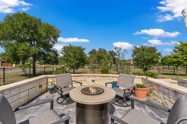 a view of a patio with table and chairs potted plants with wooden floor and fence