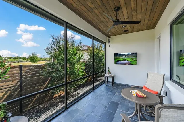 a view of a porch with furniture and a yard