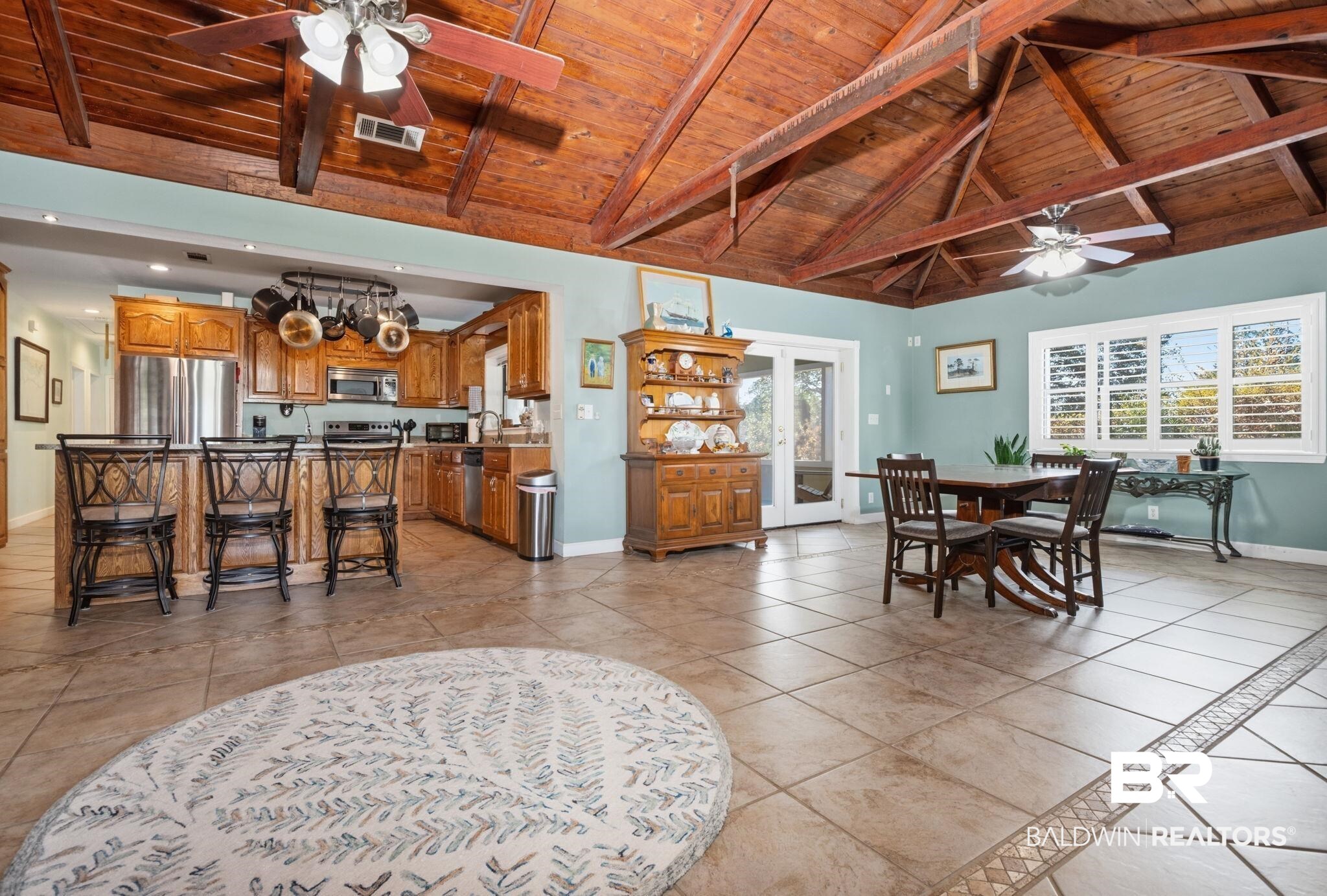 15025 Bellingrath Road Coden, AL 36523 - Photo 32 of 79 Dining area featuring ceiling fan, a high wooden beamed ceiling, and light tile patterned floors