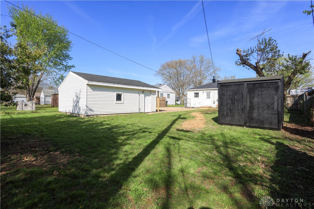 1627 Joselin Road Dayton, OH 45432 - Photo 4 of 28 This spacious backyard features lush green grass, a detached garage, and a charming storage shed.
