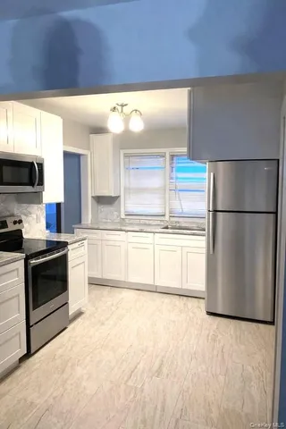 a kitchen with a refrigerator sink and stove top oven