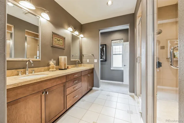 a spacious bathroom with a double vanity sink a mirror and a