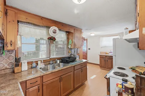 a kitchen that has a lot of cabinets and wooden floor