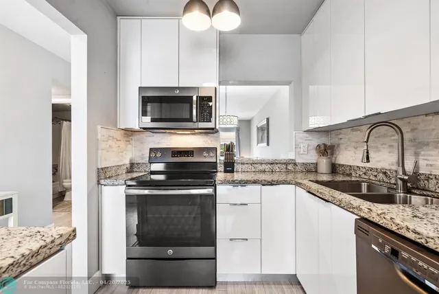 a living room with furniture a large window and stainless steel appliances
