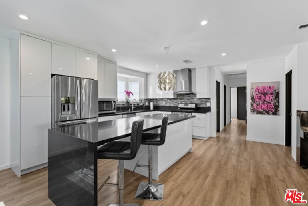 10915 Ayres Avenue Los Angeles, CA 90064 - Photo 11 of 51 a kitchen with kitchen island stainless steel appliances a refrigerator and a stove top oven