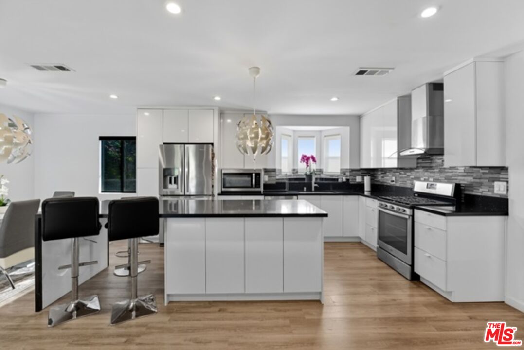 10915 Ayres Avenue Los Angeles, CA 90064 - Photo 13 of 51 a kitchen with stainless steel appliances granite countertop a stove a sink a refrigerator and white cabinets