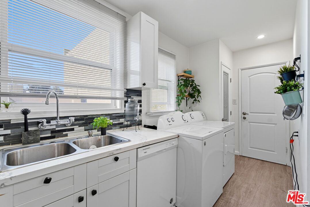 10915 Ayres Avenue Los Angeles, CA 90064 - Photo 46 of 51 a utility room with stainless steel appliances a sink a potted plant and cabinets