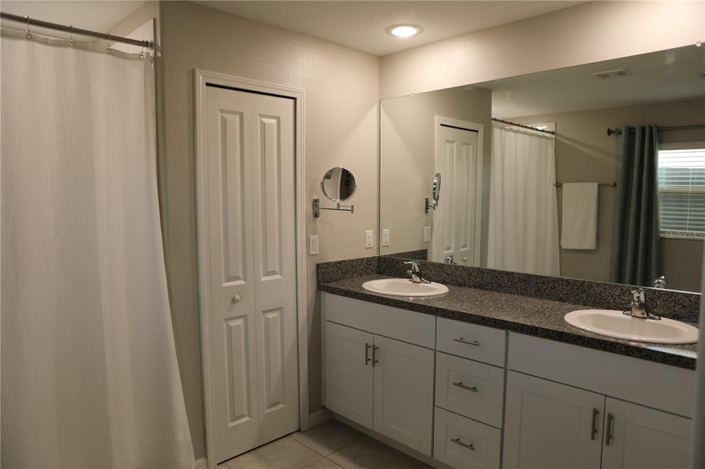 16554 Delia Street Wimauma, FL 33598 - Photo 19 of 44 a bathroom with double sink and a mirror