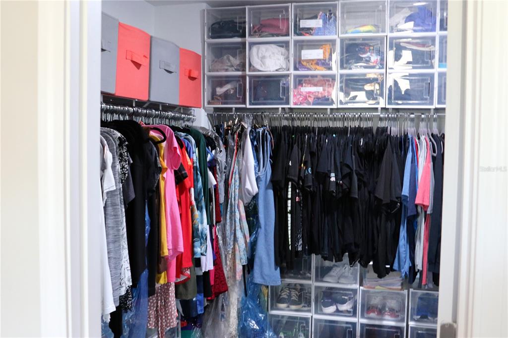 16554 Delia Street Wimauma, FL 33598 - Photo 21 of 44 a view of walk in closet with clothes